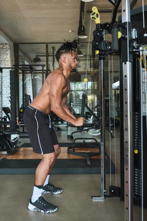 Black guy using exercise machine in gym