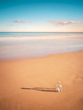 Bottle in sand near sea