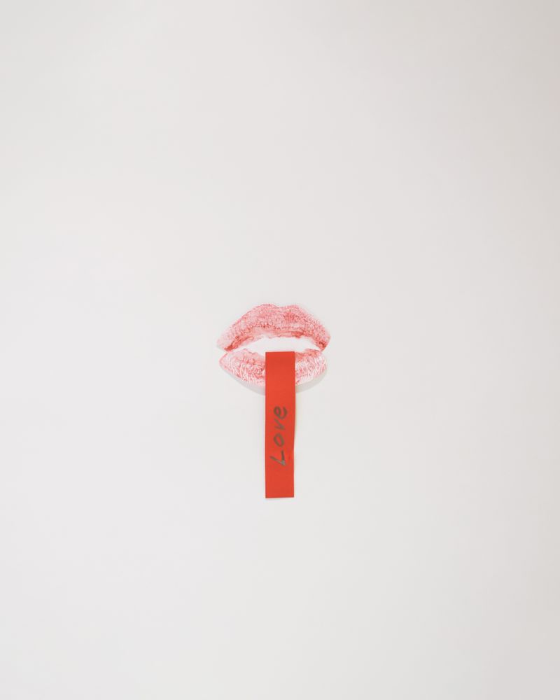 Kiss with message coming out of it on a plain background