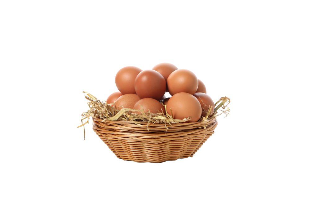 eggs in a round basket, isolated on blank background.