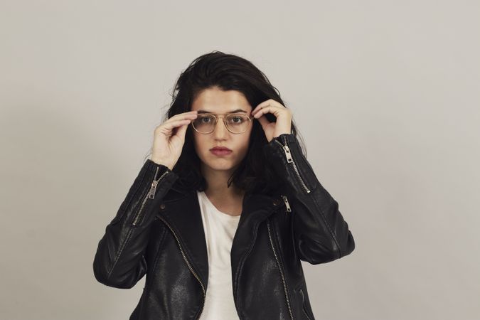 Serious pensive young female wearing leather jacket in studio