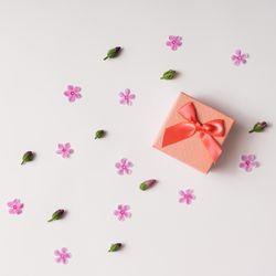 Gift box with pink flowers and buds pattern on light background