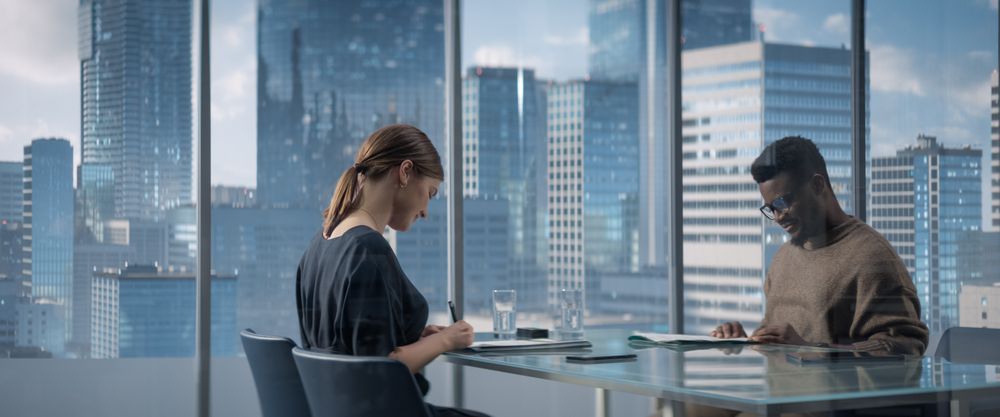Female and Male Business Partners Sign Successful Deal, Shake Hands in Meeting Room Office.