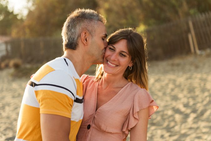 Laughing couple hugging on sandy beach