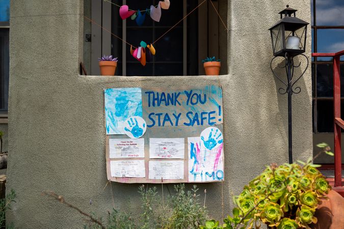 Homemade sign made by family thanking essential workers hanging in front of house