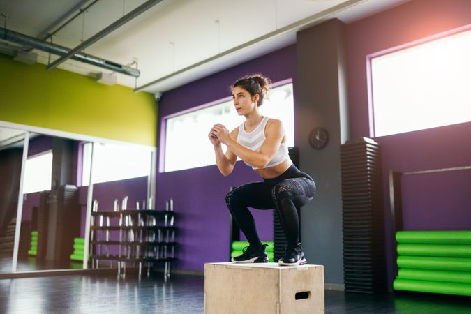 Fit woman completing a box jump