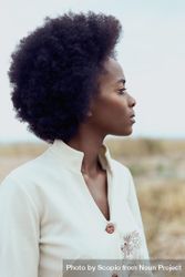 Side view of woman with afro hair under blue sky 4BrgW4