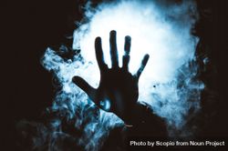 Persons 's hand in front of blue light and smoke bxMov0