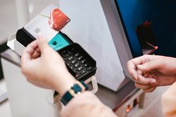 Close up of a hand with gift card at payment machine