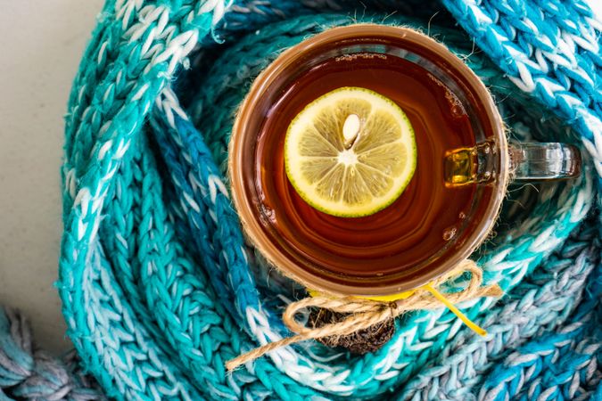 Top view of autumnal tea with pine cones wrapped in blue scarf