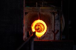 Glass product placed in furnace in blowing shop