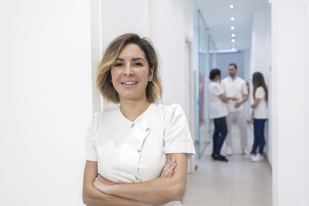 Portrait of female doctor standing with arms crossed in corridor