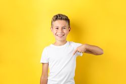 Boy in t-shirt against yellow background, space for text