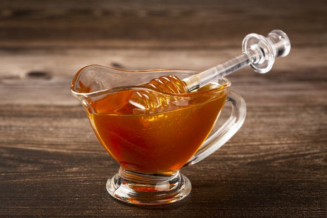 Honey in glass bowl on the table.