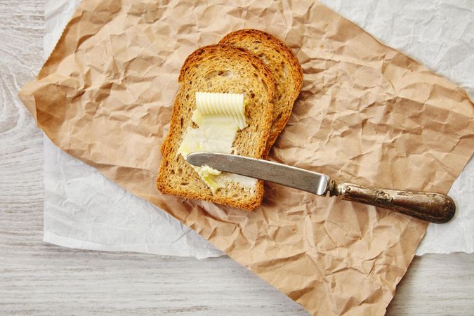 Buttered toast with knife on craft paper