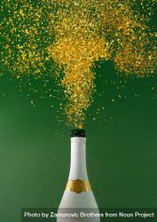 Champagne bottle explosion with golden glitter on green background 5lZNYb