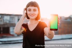 Woman smiling with smart phone outside 5XjGGb