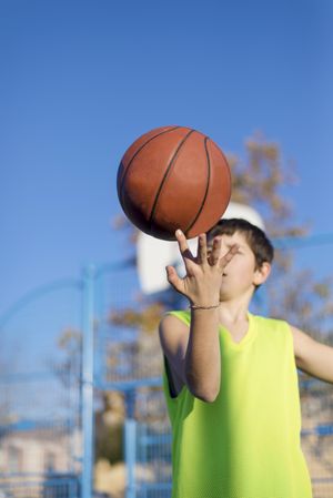 Teenager playing basketball on an outdoors court