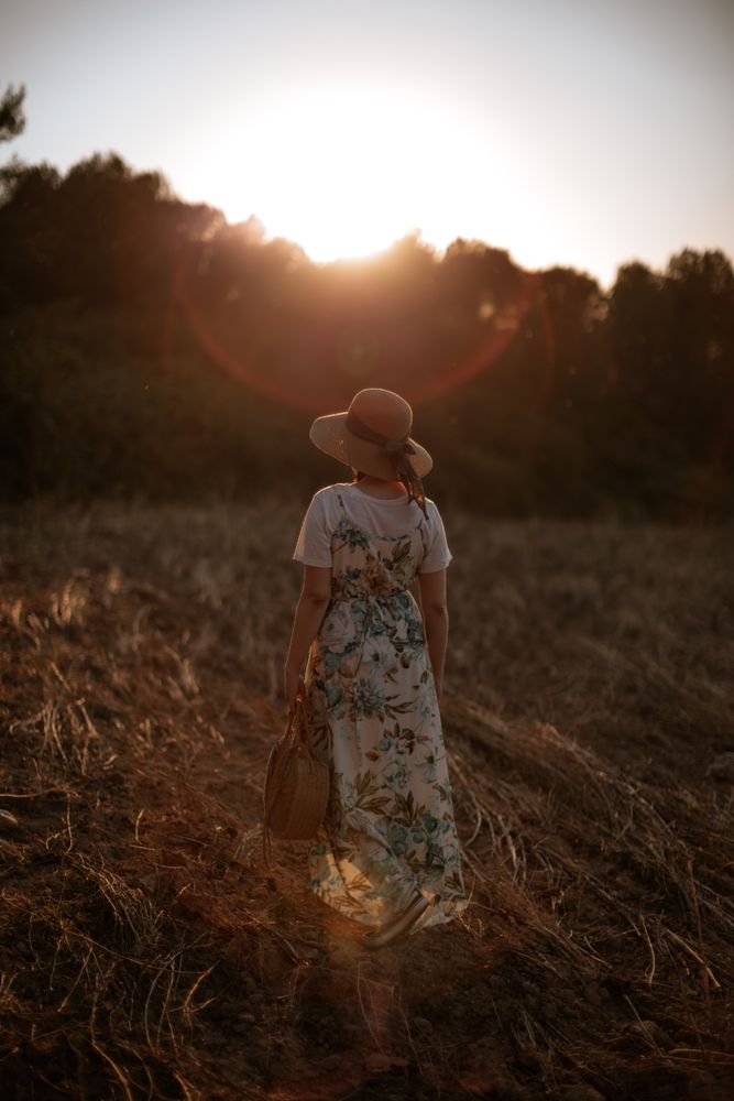 Anonymous woman walking in field