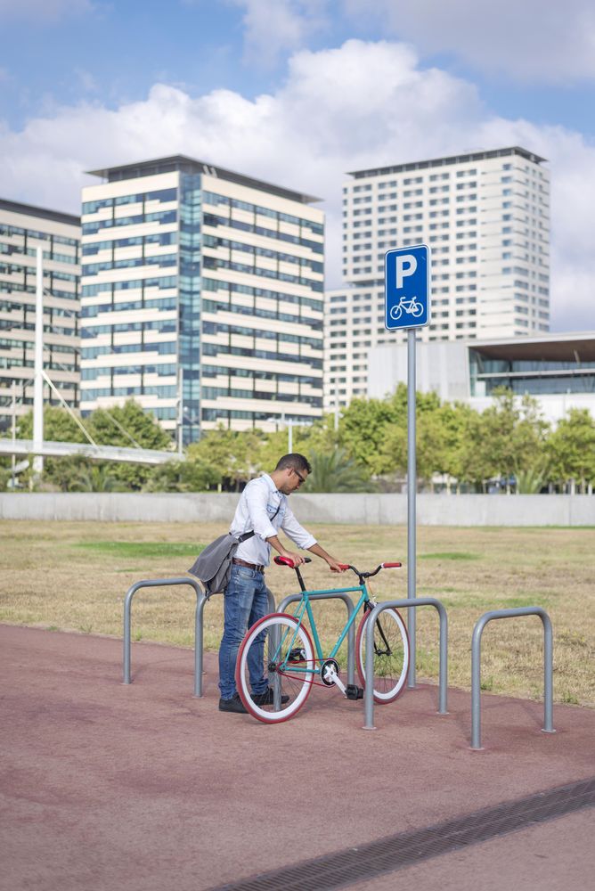 Male with colorful bicycle using rack in city