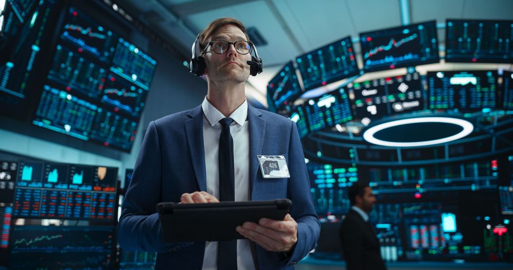 Portrait of a Young Stock Exchange Broker Using Tablet Computer, Researching Real-Time Stocks Data, Analyzing Commodities and Exchange Market Charts.