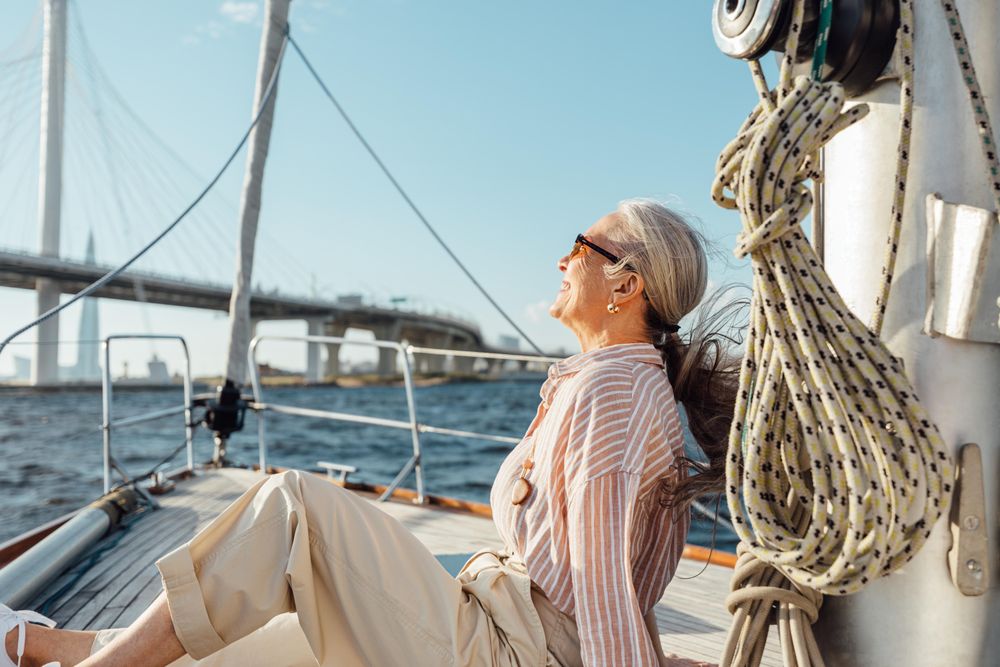 Stylish mature woman relaxing on a yacht bow