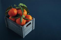 Box of tangerines on blue background