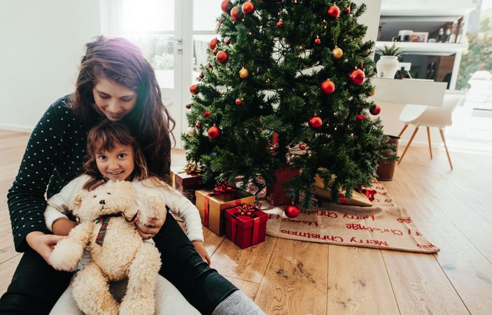Mother and daughter celebrating Christmas with teddy bear