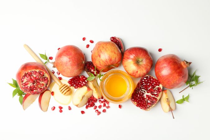 Glass honey pot with pomegranate, and an apple quarters
