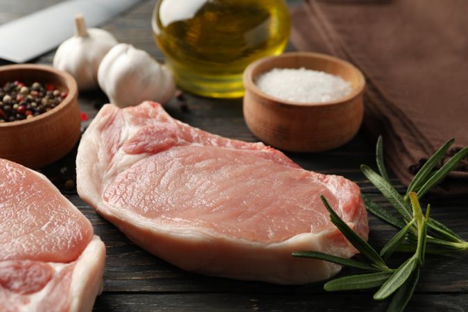 Composition with raw meat for steak and ingredients on wooden background