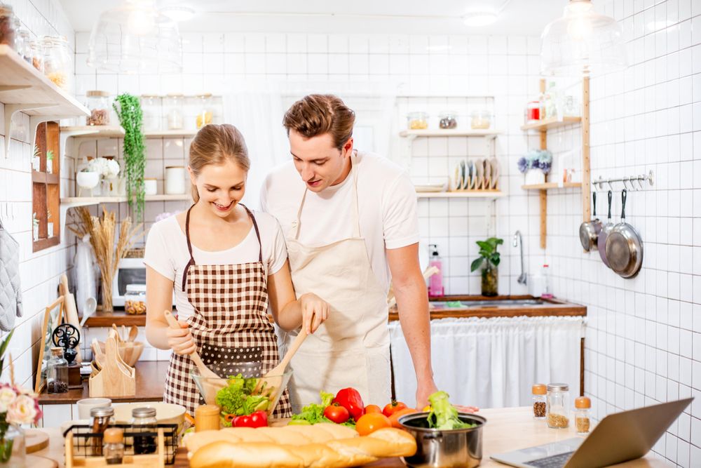 Cute couple learning to cook in the kitchen at home