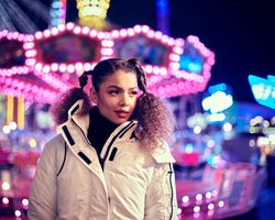 Young woman standing in front of carousel