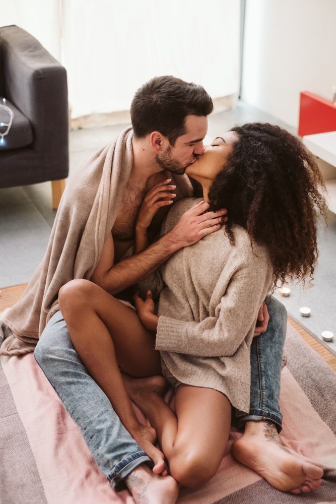 Multiethnic couple hugging on floor at home