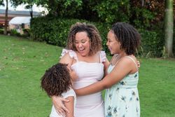 Latin American mother with her daughters smiling together.