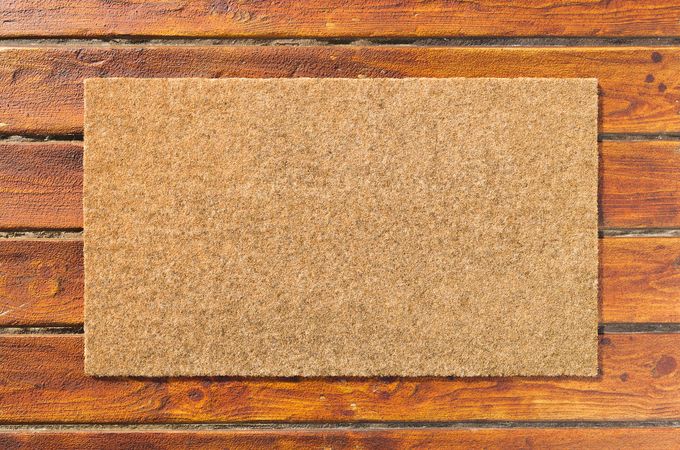 Overhead of blank doormat on the wood plank porch.