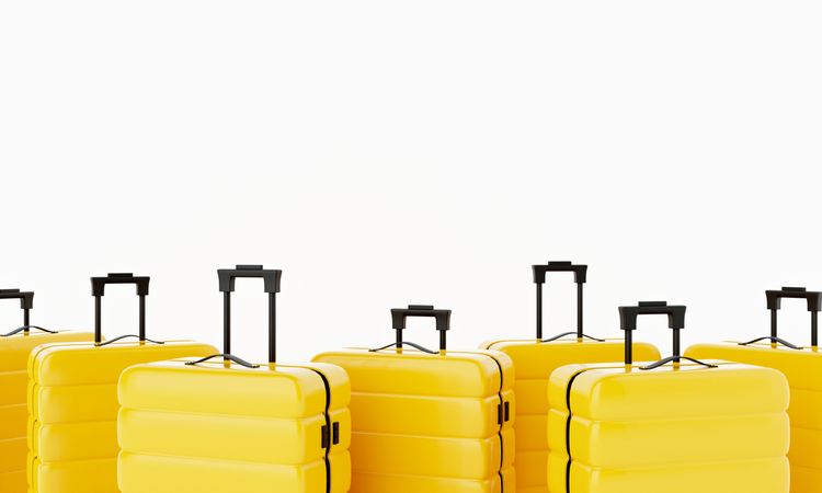Yellow hard shell roller suitcases arranged on light background