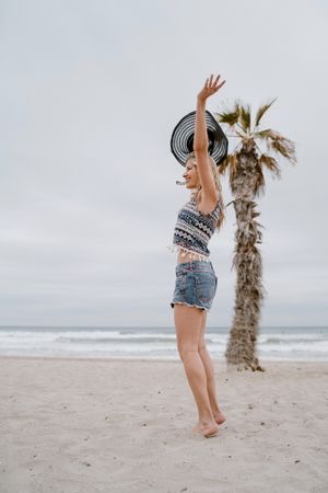 Young female relaxing on beach with hat