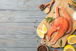 Composition with salmon meat and spices on wooden background, top view