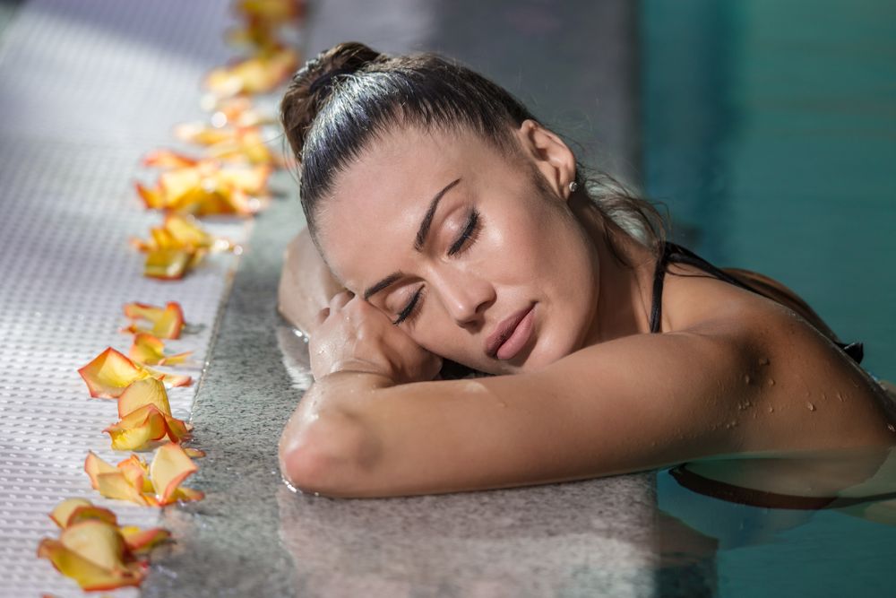 Woman leaning her her at the side of the swimming pool