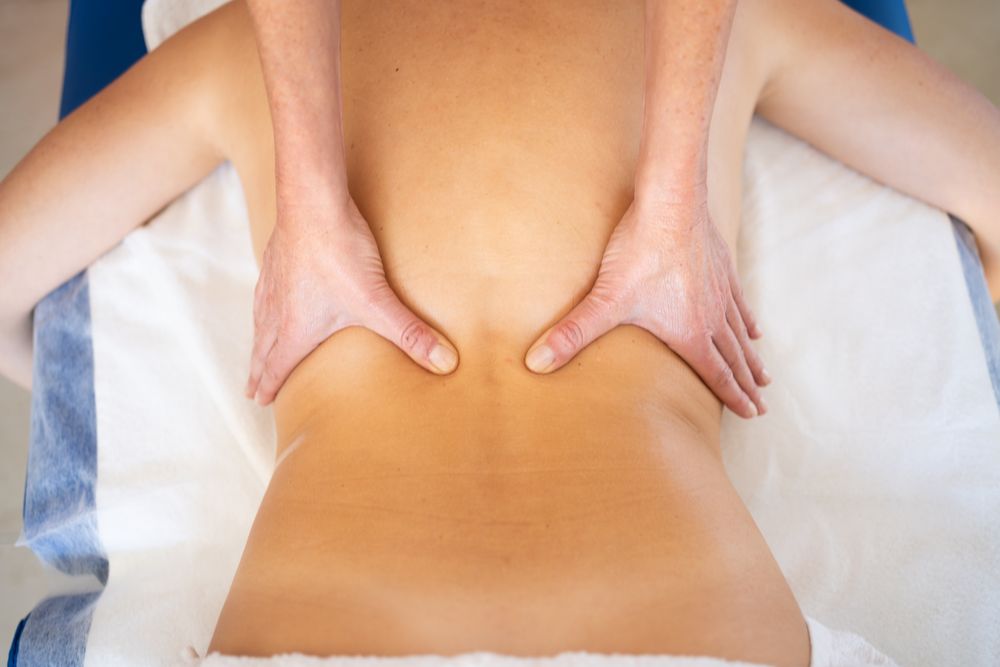 Hands of physical therapist working on client's mid back
