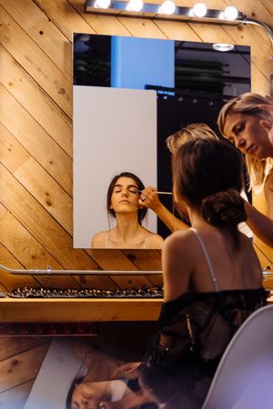 Makeup artist doing makeup for young female artist