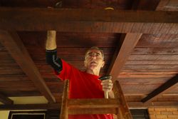 Older man working on his roof.