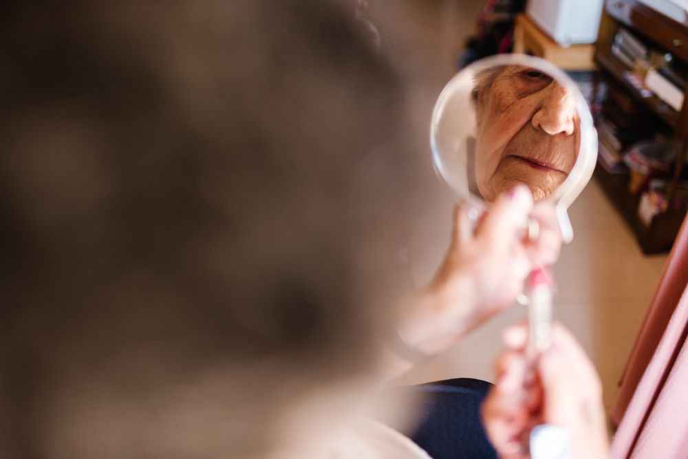 Older woman doing lips makeup at home