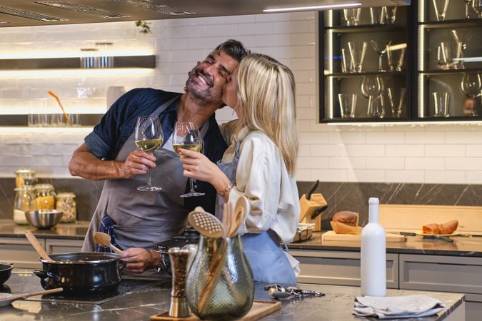 Happy couple drinking wine and cooking