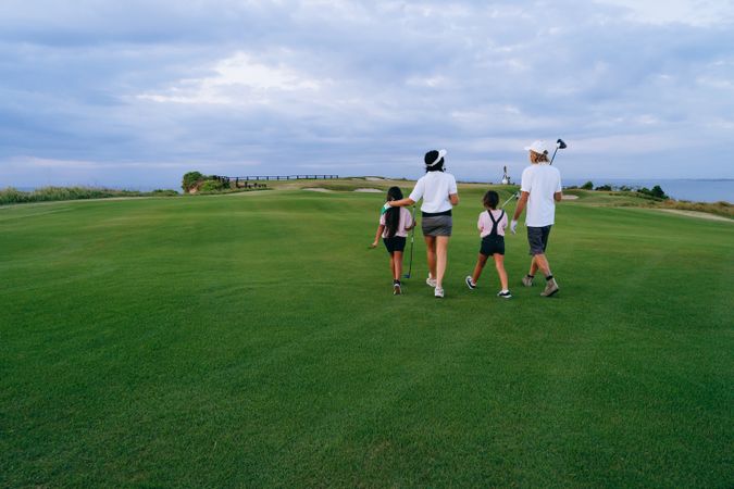Back view of family standing in golf yard