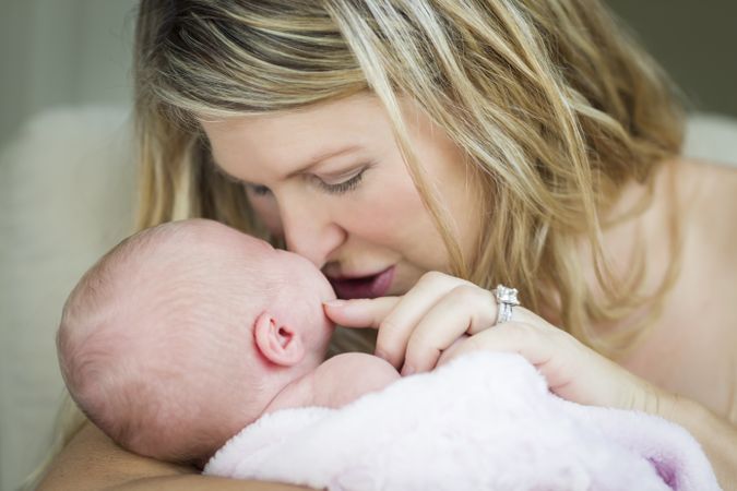 Mother Holding Her Precious Newborn Baby Girl To Her Face