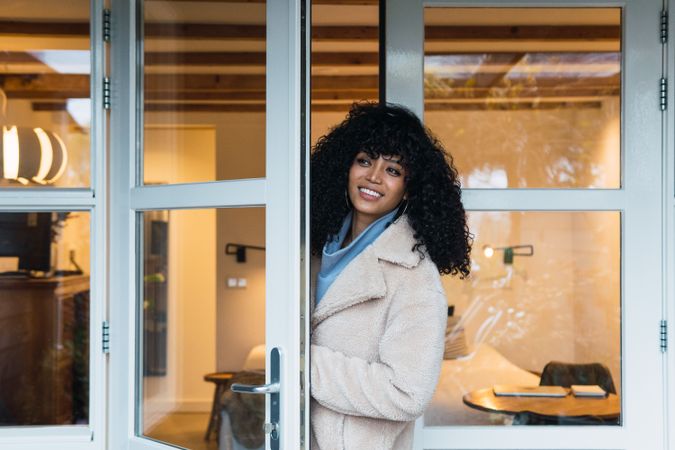 Happy Black woman standing in doorway of house