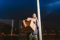 Dedicated courier phoning for delivery completion while waiting client on street in evening