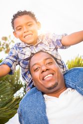 Son and Father Playing Piggyback Outdoors Together.