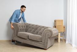 Moving concept, a man moves a sofa